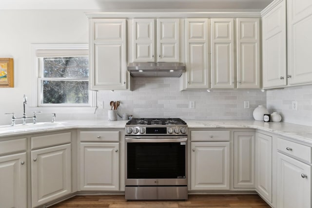 kitchen with white cabinetry, sink, stainless steel gas stove, dark hardwood / wood-style floors, and decorative backsplash