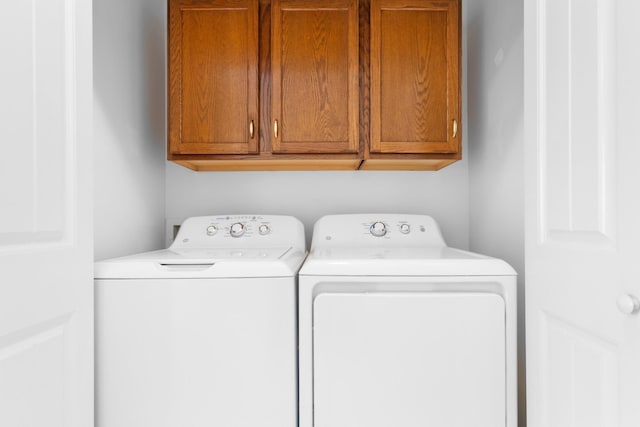 laundry area featuring washing machine and dryer and cabinets