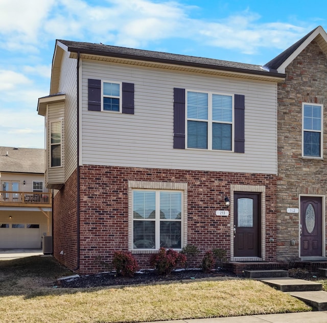 view of front of property with central AC unit, a garage, and a front yard