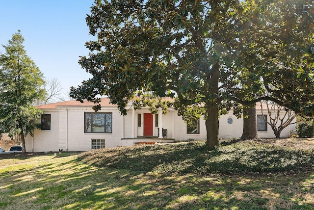 view of front facade featuring brick siding and a front yard