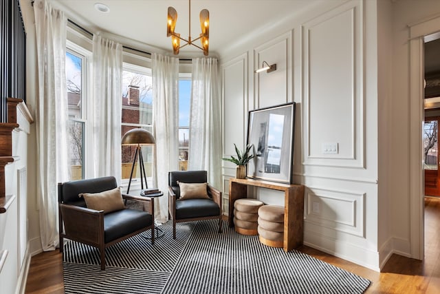 living area featuring an inviting chandelier and hardwood / wood-style flooring