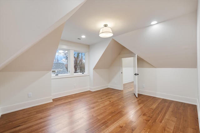 additional living space featuring lofted ceiling and hardwood / wood-style floors