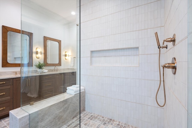 bathroom featuring a tile shower and vanity