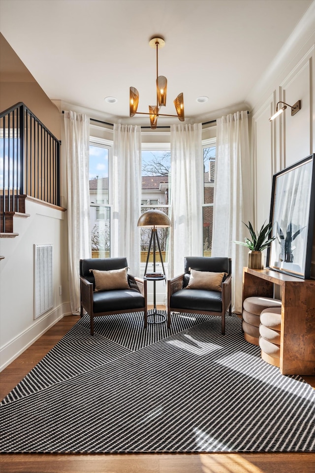 sitting room featuring hardwood / wood-style flooring and an inviting chandelier