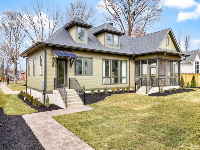 view of front of home featuring a front yard and a sunroom