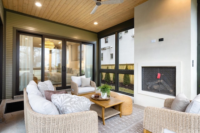 sunroom featuring ceiling fan, wood ceiling, and an outdoor fireplace