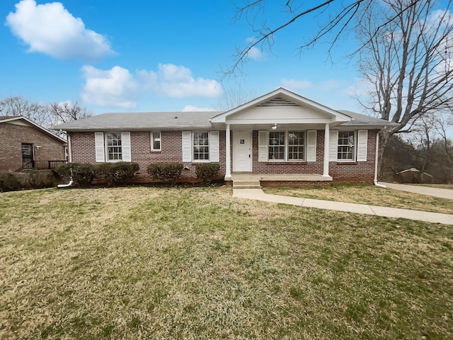 ranch-style house featuring covered porch and a front yard