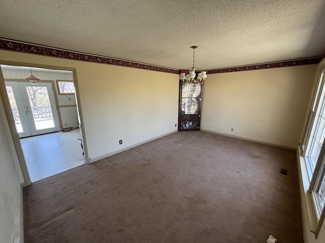 unfurnished dining area featuring a textured ceiling, a notable chandelier, light carpet, baseboards, and french doors