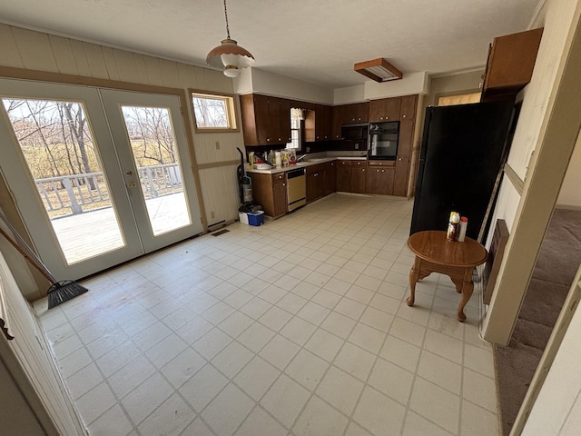 kitchen featuring dishwasher, oven, light countertops, french doors, and light floors