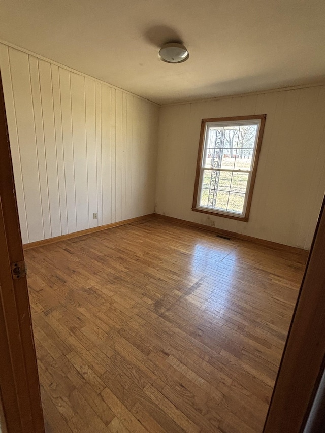 empty room featuring wood finished floors and baseboards