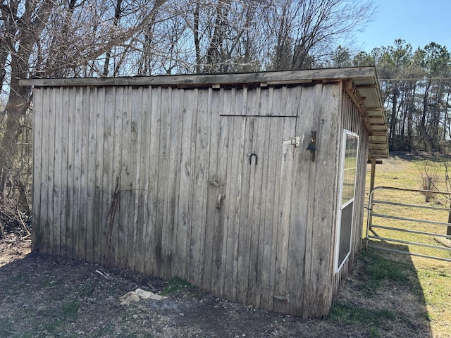 view of outdoor structure with fence and an outbuilding