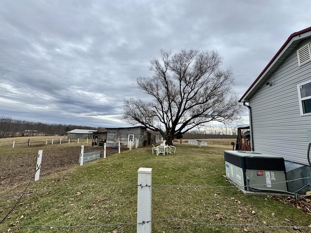 view of yard with central AC unit and a rural view