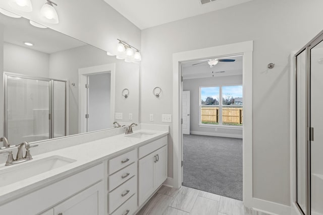 full bath featuring double vanity, a sink, and a shower stall