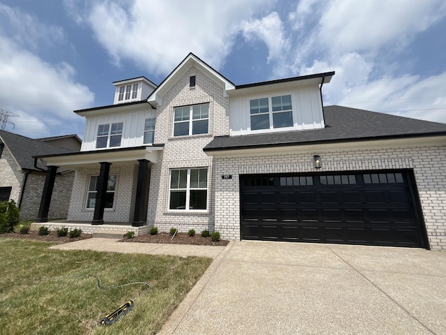 view of front of property featuring board and batten siding, concrete driveway, brick siding, and a porch