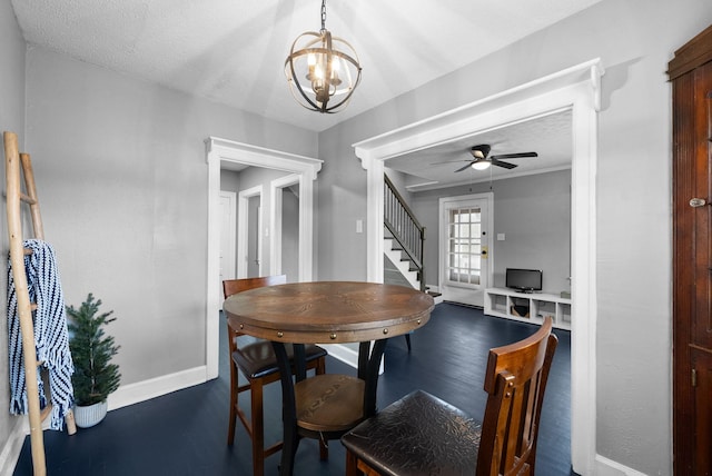 dining space featuring ceiling fan with notable chandelier and a textured ceiling