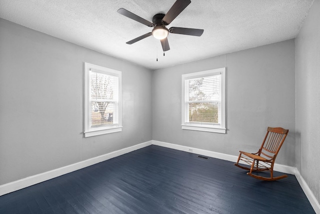 unfurnished room with ceiling fan, dark hardwood / wood-style flooring, and a textured ceiling