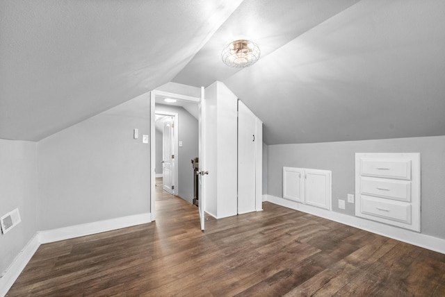 additional living space featuring lofted ceiling and dark hardwood / wood-style floors