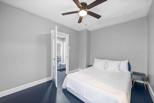 bedroom with dark hardwood / wood-style flooring and ceiling fan