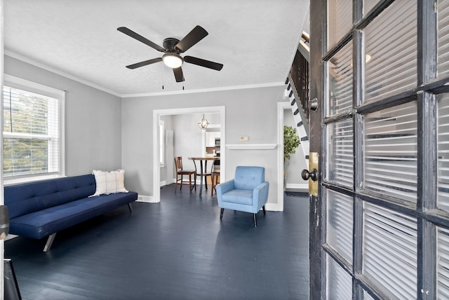 living area with ceiling fan, ornamental molding, dark wood-type flooring, and a textured ceiling