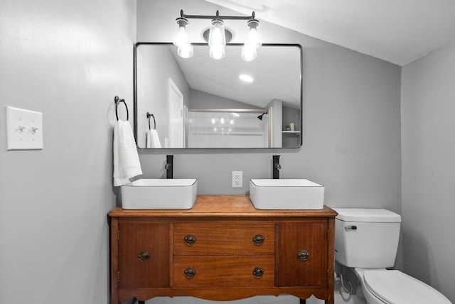 bathroom with toilet, vaulted ceiling, vanity, and walk in shower