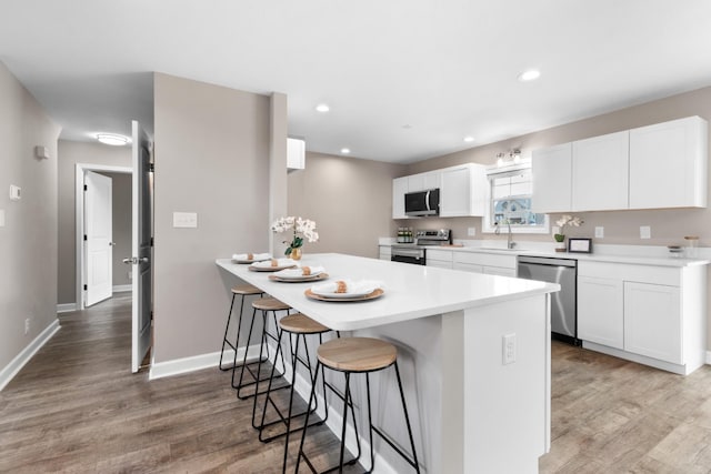 kitchen featuring stainless steel appliances, white cabinetry, and wood-type flooring