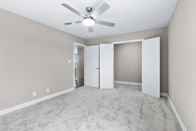 unfurnished bedroom with ceiling fan and light colored carpet