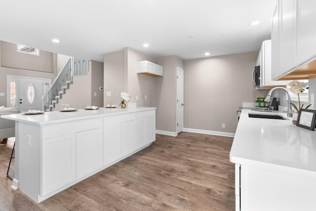 kitchen featuring light hardwood / wood-style flooring, sink, and white cabinetry