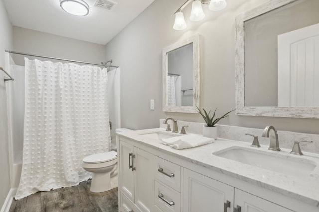 bathroom with toilet, hardwood / wood-style flooring, and vanity