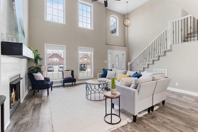 living room featuring ceiling fan, plenty of natural light, and wood-type flooring