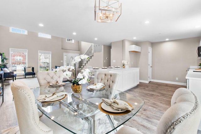 dining space with light wood-type flooring and an inviting chandelier