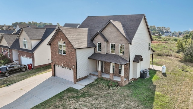 view of front of house with a front lawn, central AC, and a garage