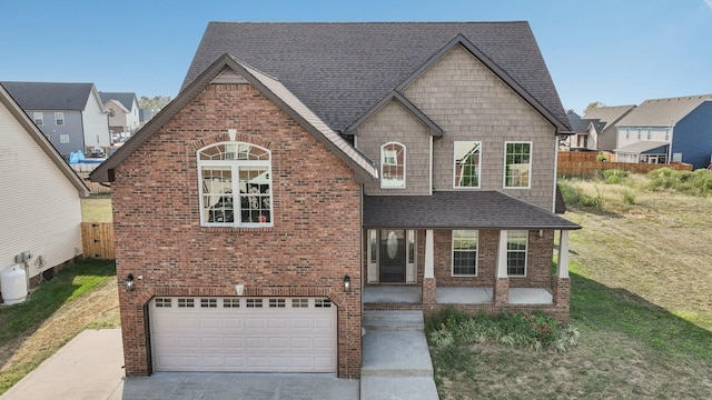 view of front facade with a front yard, a garage, and a porch