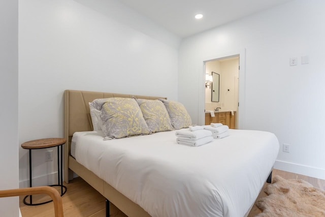 bedroom featuring light wood-type flooring and ensuite bath