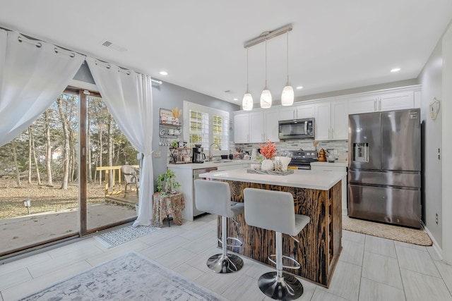 kitchen featuring a center island, white cabinetry, stainless steel appliances, and sink