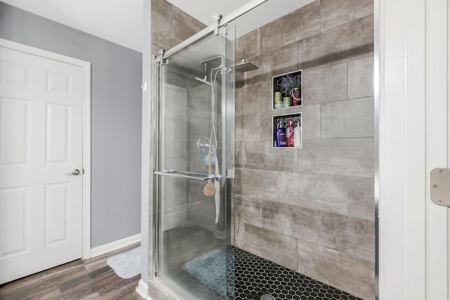 bathroom featuring hardwood / wood-style flooring and an enclosed shower