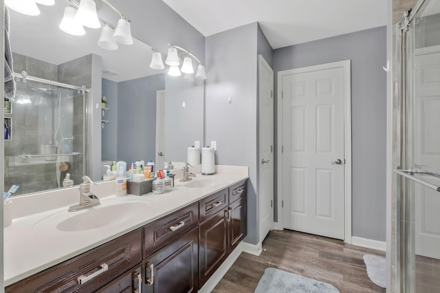 bathroom with hardwood / wood-style flooring, vanity, and a shower with shower door