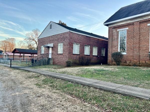 view of property exterior featuring a yard and a carport