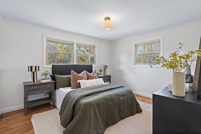 bedroom featuring crown molding, multiple windows, and wood-type flooring