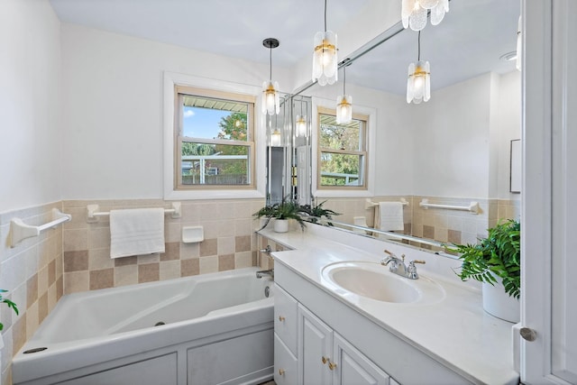 bathroom with tile walls, vanity, and a bath