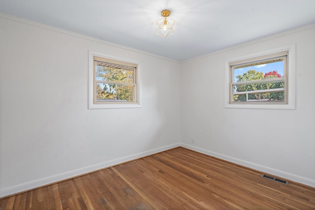 empty room featuring hardwood / wood-style floors and crown molding