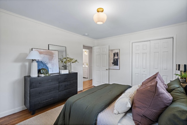 bedroom with ornamental molding, dark hardwood / wood-style flooring, and a closet