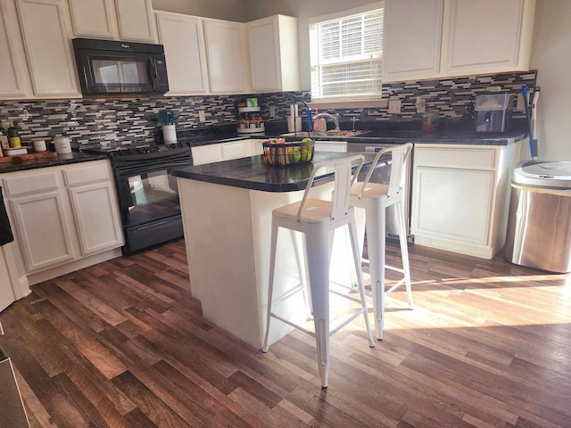 kitchen featuring dark countertops, a sink, black appliances, and dark wood-style flooring