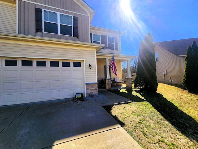 view of front of property with a garage, board and batten siding, concrete driveway, and a front yard