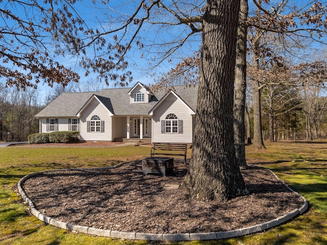 cape cod house featuring a shingled roof and a front yard