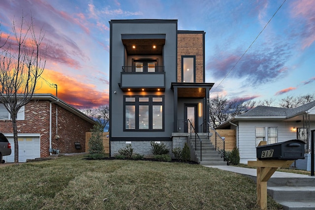 view of front of home with a garage, a yard, and a balcony