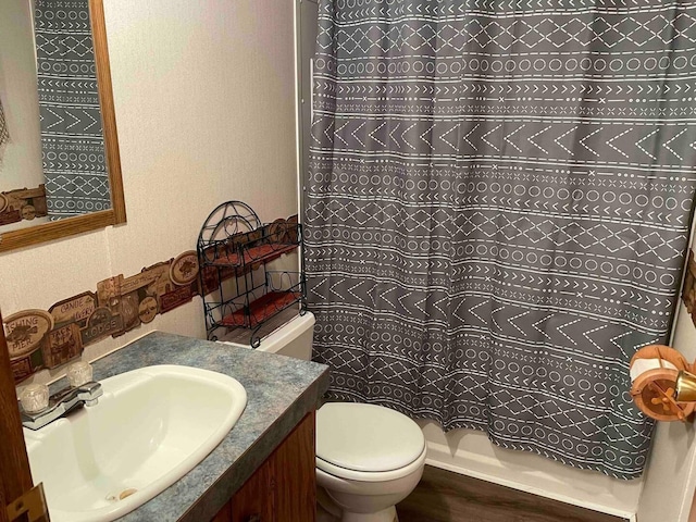 bathroom with toilet, vanity, and walk in shower