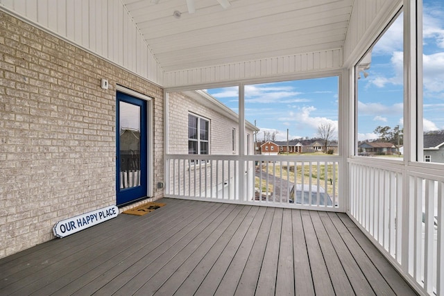 unfurnished sunroom featuring vaulted ceiling