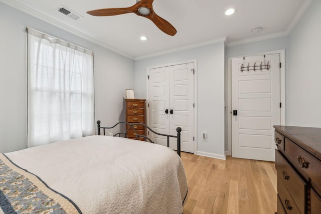 bedroom with ceiling fan, light hardwood / wood-style flooring, crown molding, and a closet