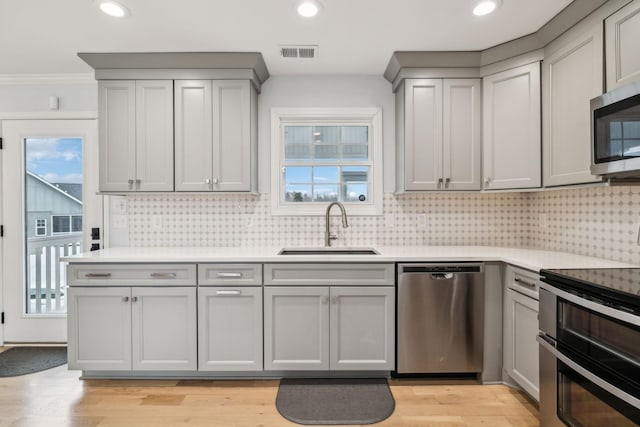 kitchen featuring gray cabinets, light hardwood / wood-style flooring, sink, and stainless steel appliances