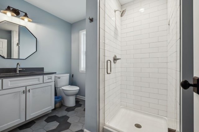 bathroom featuring vanity, toilet, a shower with shower door, and tile patterned floors